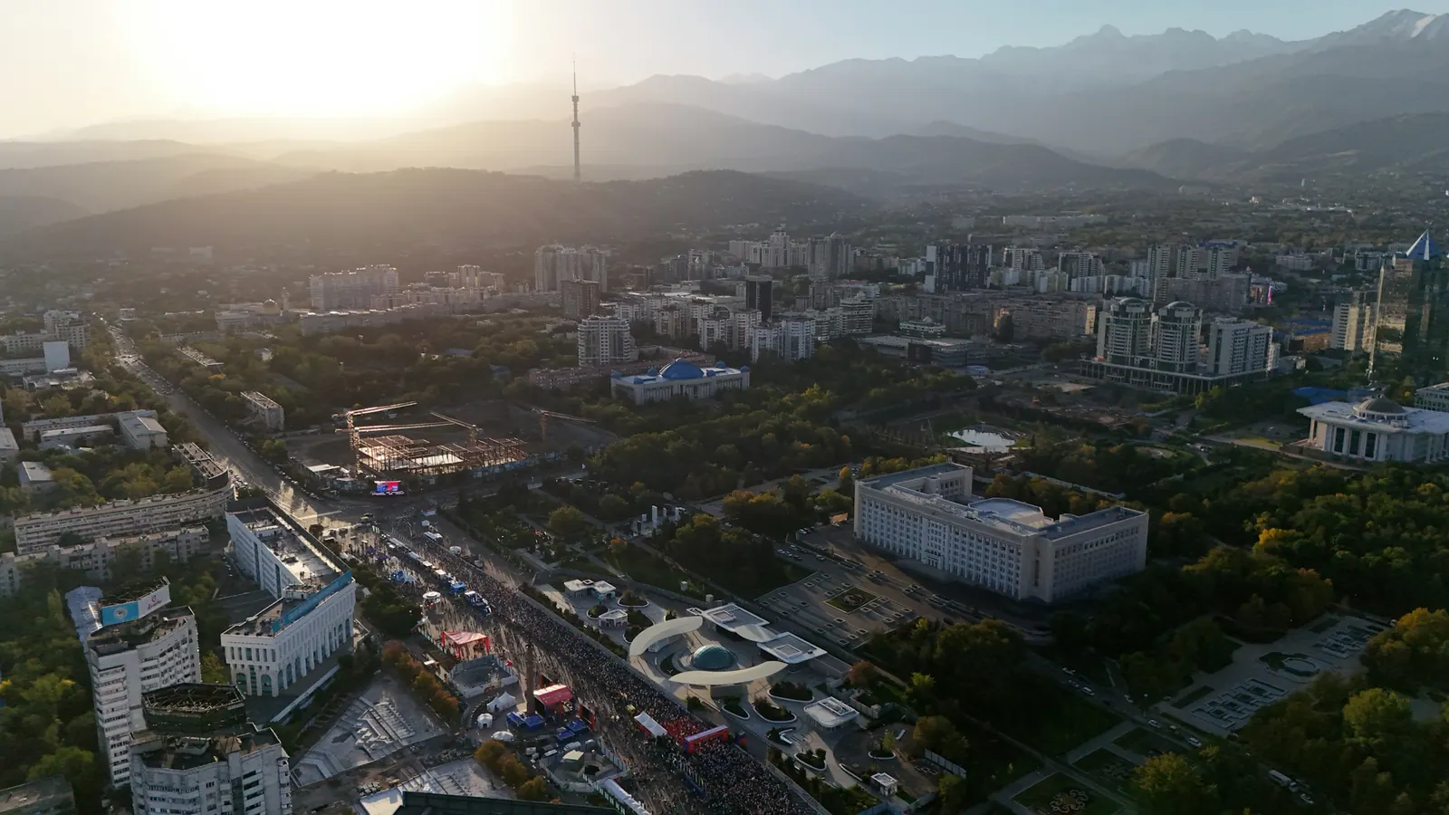 Панорама Алматы: городские кварталы и горы на закате